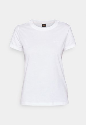 Hvit bomull T-skjorte med rund hals, korte ermer og en subtil brodert logo på brystet. Glatt tekstur, avslappet design.