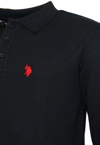 Čierna polokošeľa s dlhými rukávmi a golierom, so tromi gombíkmi a červeným vyšitým logom jazdca na koňovi na hrudi.