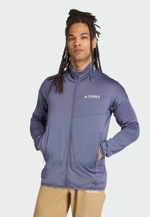Men's Terrex jacket in light blue, featuring a front zipper, high collar, and a chest pocket, made from lightweight, textured fabric.