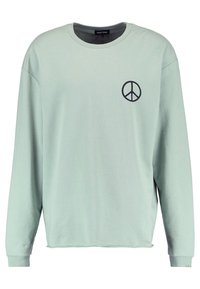 Felpa a maniche lunghe verde menta con scollatura rotonda. Presenta un simbolo della pace nero stampato sul petto sinistro. Design morbido e casual.