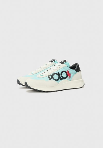 Adidașii au un upper din plasă de culoare albastru deschis cu accente din suede crem, un capac pe călcâi de culoare neagră și un logo „POLO” proeminent de culoare neagră cu detalii roșii în formă de cal.