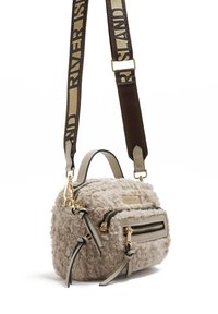 Fuzzy beige handtas met gouden ritsen, dubbele ritscompartimenten en contrasterende hengsels in bruin en beige met tekst. Bevat metalen accenten.