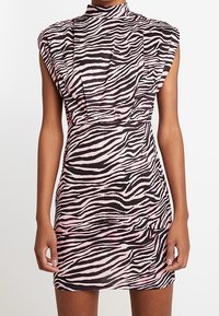 Vestido con estampado de cebra hecho de una tela texturizada, con un cuello alto, hombros estructurados y una silueta ajustada en negro y rosa.