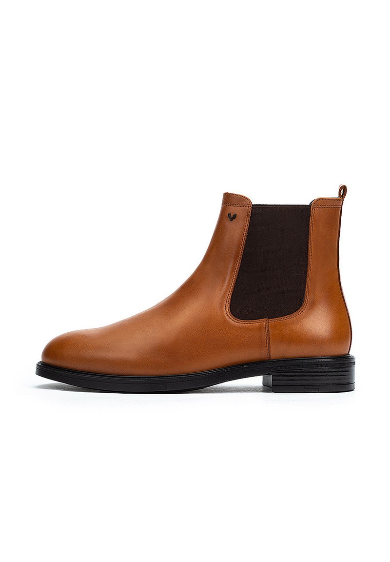 Bota Chelsea de cuero marrón con paneles laterales elásticos, punta redondeada y un tacón bajo apilado. Textura suave y diseño minimalista.
