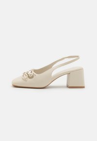 Pantofi cu toc slingback bej, cu vârf ascuțit, având o aplicație sub formă de fundă și un toc pătrat. Material din piele netedă, design simplu.