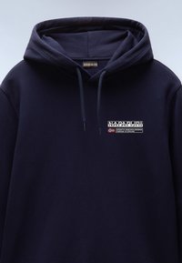 Felpa blu navy realizzata in cotone. Presenta un cappuccio con coulisse, dettagli con logo anteriore e una vestibilità rilassata. Tessuto testurizzato con una finitura morbida.