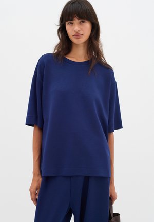 T-shirt oversize bleu marine en coton doux, doté de manches courtes, d'un col rond et d'une coupe décontractée avec une texture lisse.