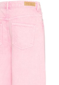 Rausvos šviesios spalvos džinsų iš nugaros vaizdas, su dviem kišenėje esančiais lopais ir odine prekės ženklo „ICHI“ etikete ant juosmens.