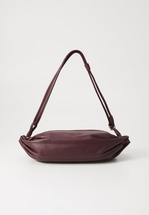 Burgundy leather shoulder bag with a flat silhouette, adjustable straps, and gathered side details for added texture.