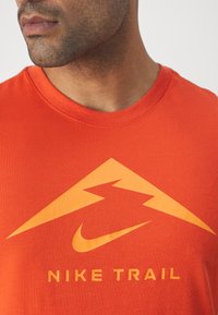 Nike Performance TEE TRAIL LOGO - Spordi T-särk - cosmic clay