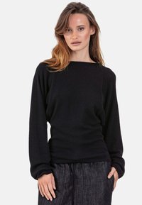 Schwarzer Strickpullover mit weitem Ausschnitt und langen Ärmeln, mit einem lockeren Schnitt. Die Textur ist glatt mit einem subtilen Glanz.