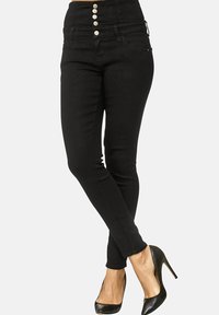 Schwarz hochtaillierte Jeans mit einem Fünfknopfverschluss, Slim Fit, Fronttaschen und glatter Textur. Kombiniert mit schwarzen High Heels.