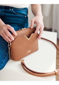 Braune Handtasche mit strukturiertem Gewebe, geometrischem Muster, goldenen Beschlägen, Reißverschluss und abnehmbarem Kettenriemen.