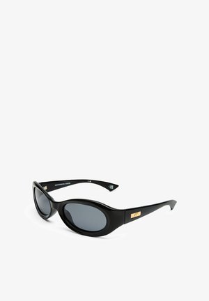 Černé sluneční brýle s oválnými skly, matným rámem a zlatým akcentem na spáncích. Tmavě šedá skla poskytují UV ochranu.