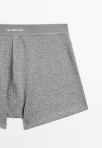 Grå bomullboxer med ett brett elastiskt midjeband som har varumärket "Massimo Dutti" i vit text.