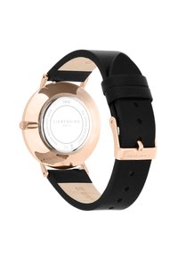 Zwart silicone horloge met een roségouden roestvrijstalen kast. Heeft een ronde glazen achterkant die interne details weergeeft, met een gemonteerd logo.