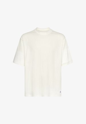 White cotton t-shirt with short sleeves, round neckline, relaxed fit, and subtle stitching detail. Small logo at the bottom right.
