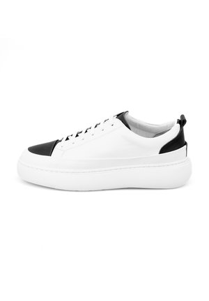 Baskets en cuir blanc avec des accents noirs, bout arrondi, semelle blanche épaisse et design à lacets. Texture lisse avec des détails minimaux.