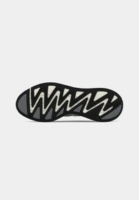 Sort gummisål med et zigzag mønster. Har hvide og grå accenter for bedre traction. Glat finish med vinklede konturer.