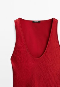 Červený top bez rukávů s hlubokým výstřihem do V a textilní strukturou s jemným leskem. Na štítku je nápis "Massimo Dutti."