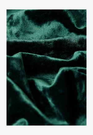 Diepgroen fluwelen stof, zachte textuur, met zichtbare plooien en kreuken, die een rijke glans en diepte in kleur laat zien.