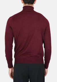 Maglione a collo alto bordeaux realizzato in morbido tessuto a maglia, con maniche lunghe, colletto e polsini a costine, dalla silhouette aderente.