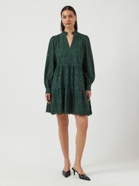 Green embroidered dress with a V-neck, long puff sleeves, and scalloped hem. Features intricate cut-out patterns and a flared skirt.