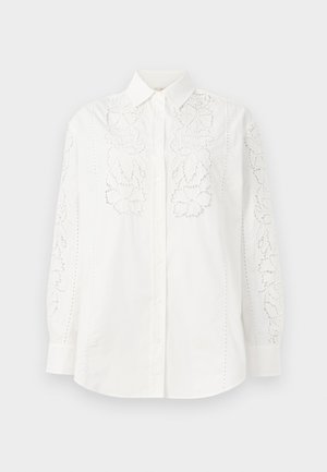 Chemise blanche à boutons avec des détails en dentelle florale sur les deux manches et à l'avant. Fabriquée en coton avec un col classique et des manches longues.