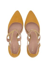 Chaussures à talons hauts en daim jaune avec bouts pointus, brides à la cheville et semelle intérieure couleur nude. Présentent un subtil accent doré sur les brides.