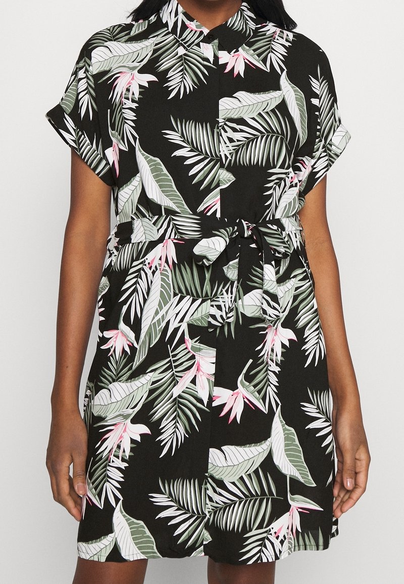 Robe noire à manches courtes avec imprimé de feuilles tropicales vertes et blanches et fleurs roses, fermeture boutonnée devant et ceinture à nouer à la taille.