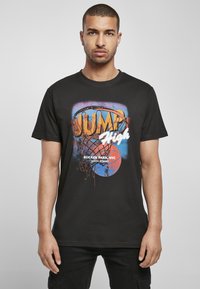 Melns kokvilnas T-krekls ar krāsainu basketbola grafiku, "JUMP High," un tekstu "RUCKER PARK, NYC 156TH STREET" treknā, košā burtveidā.