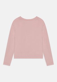 Top a maniche lunghe in cotone morbido color rosa pallido, con colletto a girocollo, vestibilità rilassata e orlo dritto. Design minimalista senza loghi o dettagli visibili.