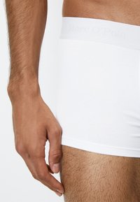 Hvide bomulds-boxerbriefs med en blød talje, der har diskret branding. Glat tekstur, tætsiddende design og længde til midt på låret.