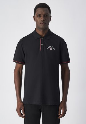Polo shirt nero in cotone con colletto, due bottoni, cuciture di accentuazione rosse e logo "Champion" bianco sul petto.