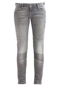 Jeans gris de corte slim hechos de denim. Con detalles acanalados en las rodillas, cinco bolsillos y una cinturilla clásica con pasadores para cinturón.