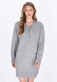 Rochie tricotată gri cu un guler cu nervuri, detaliu legat, mâneci lungi și două buzunare frontale. Textură moale, design până la genunchi.