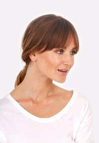 Nekovrtnik iz rožnatega zlata, geometrijski uhani, ki jih nosi ženska s rjavimi lasmi, z elegantnim pravokotnim dizajnom na svetli ozadju.