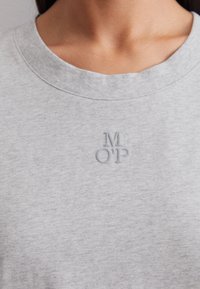 Grijze katoenen sweatshirt met een geribde ronde halslijn, met een subtiel reliëflogo "M OP" op de borst. Zachte textuur.