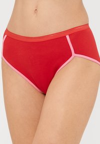 Piros pamut bikini alsó, rózsaszín rugalmas derékpánttal és varrás kiemelésekkel, klasszikus szabással és sima textúrával.