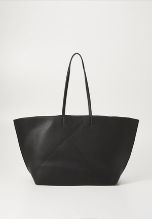 Bolso tote de cuero negro con asas largas y sutiles detalles de costura diagonal en la parte frontal, apoyado sobre un fondo blanco.