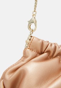 Ruusunpunainen keinonahkainen käsilaukku, jossa on kerätty tekstuuri ja kultainen ketjusangallinen sekä hummeriklipsi-muotoinen metalliositus.