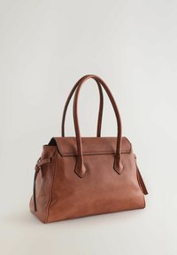Hnědá kožená kabelka se dvěma zaoblenými úchyty, strukturovaným tvarem a klopovým zapínáním. Má prošité detaily a hladkou texturu.