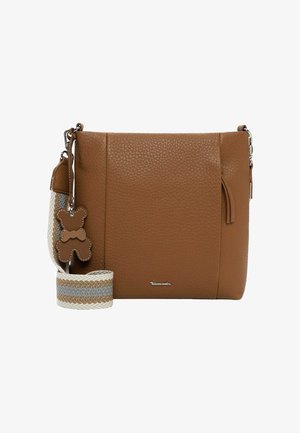 Hnědá texturovaná kožená kabelka přes rameno s proužkovaným látkovým popruhem a malým přívěskem ve tvaru plyšového medvídka na bílém pozadí.