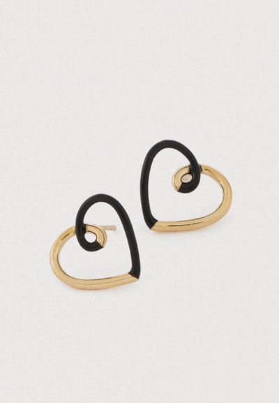 Sirds formas auskari ar zelta un melnu krāsu kombināciju, izveidoti no gluda metāla mūsdienīgā dizainā.