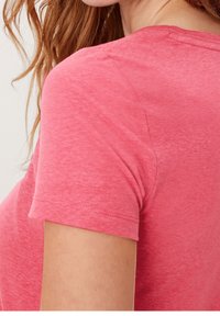 Tričko s krátkým rukávem a kulatým výstřihem vyrobené z měkké heather růžové látky. Má volnější střih a šití na rukávu a lemování.