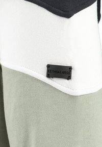 Sudadera con bloques de color en negro, blanco y verde oliva. Presenta una tela texturizada y una pequeña etiqueta negra con la marca "KEY LARGO".