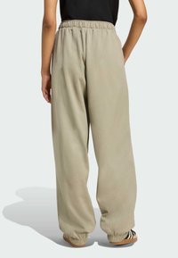 Lys beige sweatpants med afslappet pasform, elastisk talje og manchetter ved anklerne. Blød stoftekstur og minimalistisk design uden mønstre.