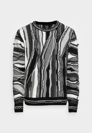 Pull en tricot à manches longues avec motifs abstraits verticaux et ondulés en noir, blanc et gris, col rond, poignets et ourlet en côtes.