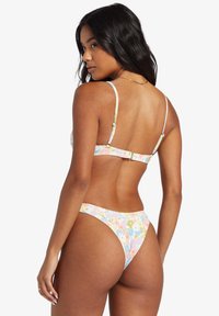 Bikiny s kvetinovým vzorom v pastelových farbách, s tenkými ramienkami a nastaviteľným uzáverom na chrbte. Materiál vyzerá štruktúrovaný a elastický.