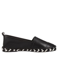Espadrilles planas de cuero negro con suela de yute trenzado en negro y blanco, con punta redonda y un pequeño lazo en la parte trasera para facilitar el uso.